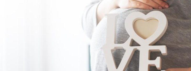 Mujer embarazada dándole amor a su hijo